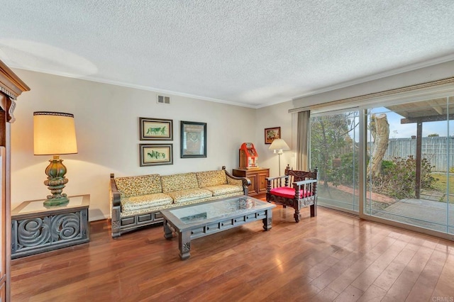 living room featuring hardwood / wood-style floors, crown molding, and a textured ceiling