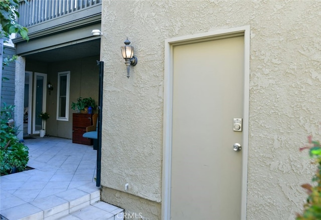 view of exterior entry featuring a balcony