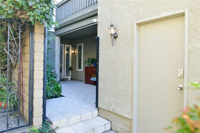 view of exterior entry with a balcony