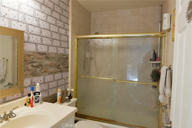 full bathroom with vanity, bath / shower combo with glass door, and toilet