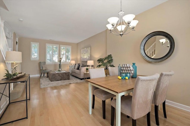 dining area with light hardwood / wood-style flooring and a chandelier