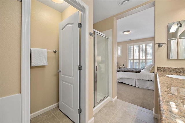 bathroom featuring a shower with door, vanity, and tile patterned flooring