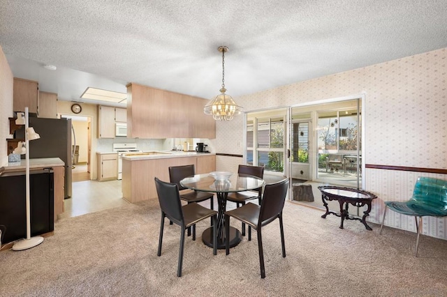 dining area featuring light colored carpet, a notable chandelier, and a textured ceiling