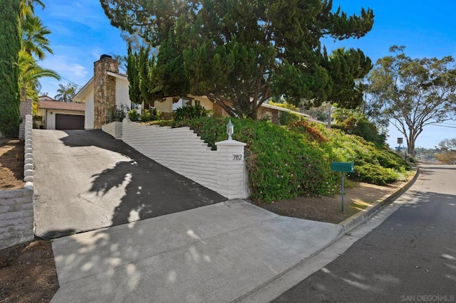 view of property hidden behind natural elements with a garage