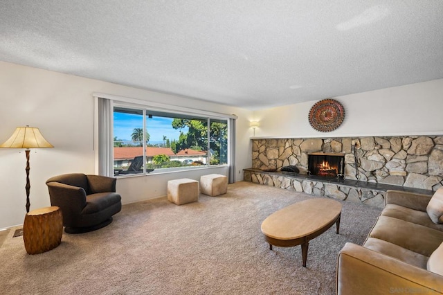 carpeted living room featuring a fireplace and a textured ceiling