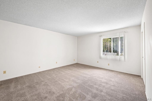 carpeted spare room featuring a textured ceiling