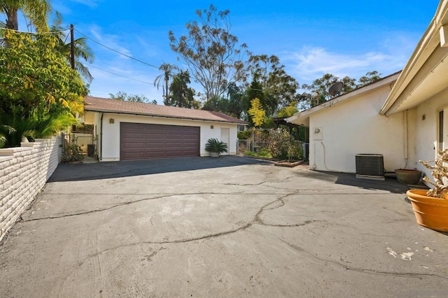 exterior space with a garage and central AC