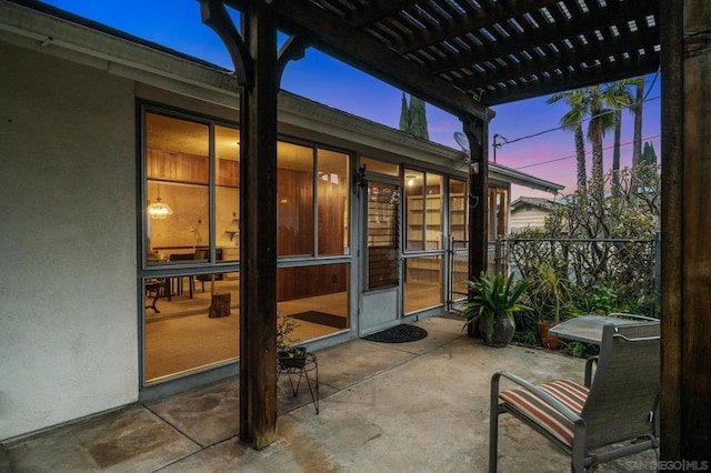 patio terrace at dusk featuring a pergola