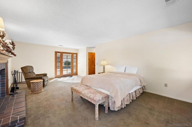 bedroom featuring access to exterior, dark carpet, a brick fireplace, and a textured ceiling