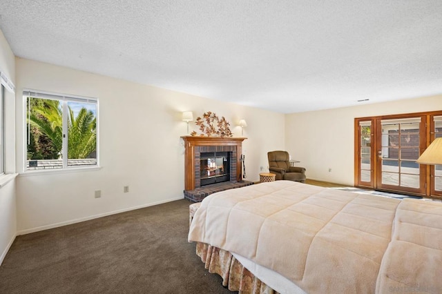 carpeted bedroom featuring access to outside, a textured ceiling, and a fireplace