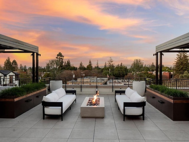 patio terrace at dusk with an outdoor living space with a fire pit