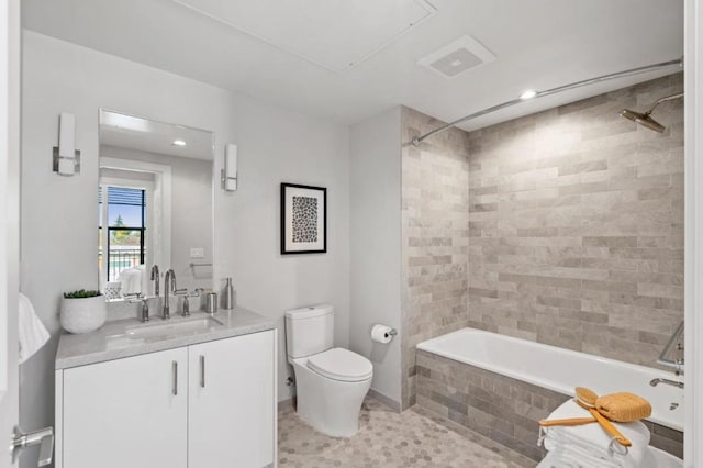 full bathroom featuring tiled shower / bath, vanity, toilet, and tile patterned floors