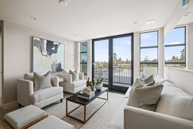 living room with expansive windows, plenty of natural light, and light wood-type flooring