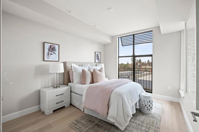 bedroom featuring floor to ceiling windows and light wood-type flooring