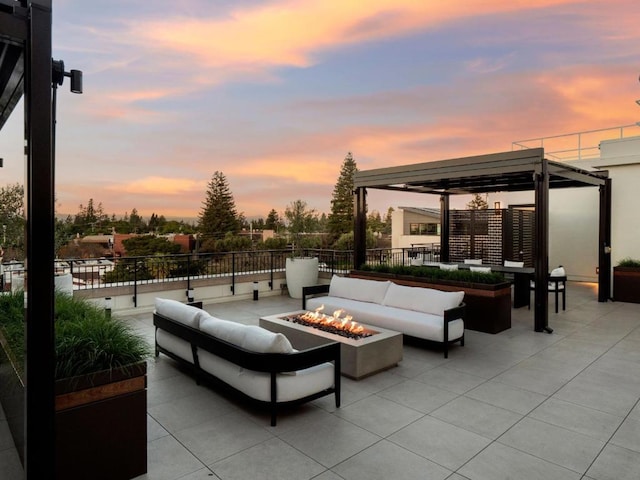 patio terrace at dusk with an outdoor living space with a fire pit