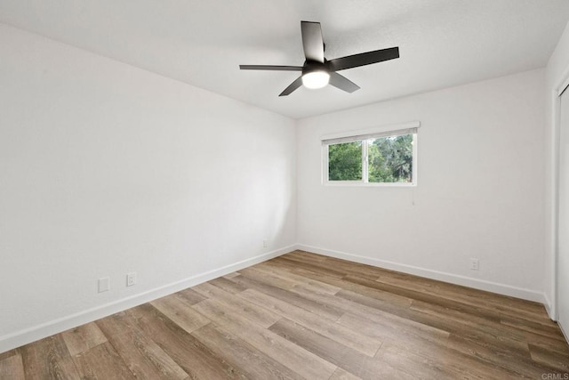 spare room with ceiling fan and light wood-type flooring