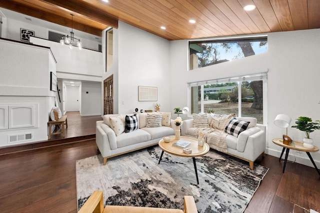 living room with a high ceiling, dark hardwood / wood-style floors, a chandelier, and wood ceiling