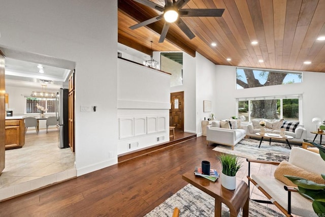 living room with high vaulted ceiling, ceiling fan with notable chandelier, wood ceiling, and light hardwood / wood-style floors