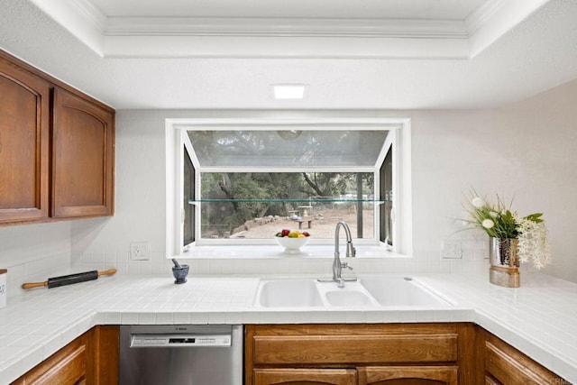 kitchen featuring sink, crown molding, tile countertops, and stainless steel dishwasher