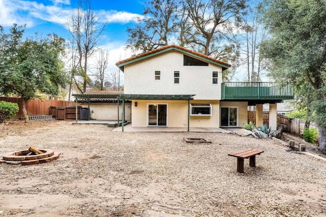 rear view of house featuring a patio and a fire pit