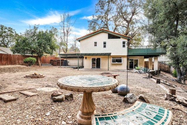 rear view of property featuring a fire pit and a patio area