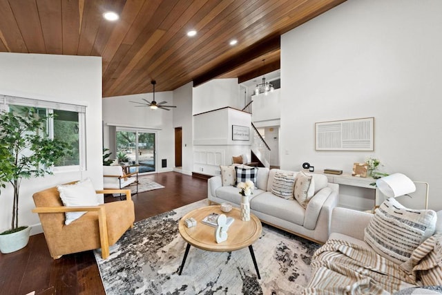 living room with dark wood-type flooring, ceiling fan, high vaulted ceiling, and wooden ceiling