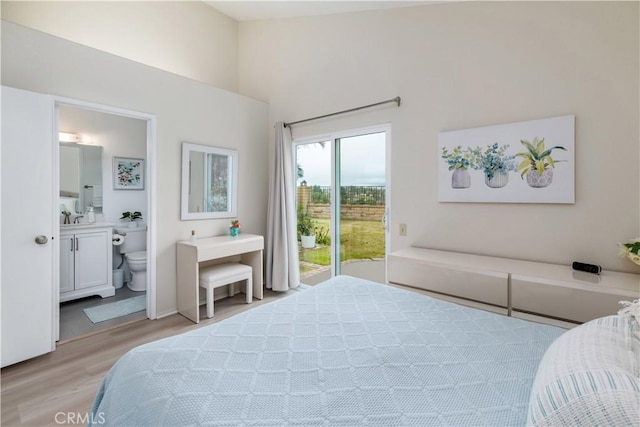 bedroom featuring ensuite bathroom, sink, access to exterior, and light wood-type flooring