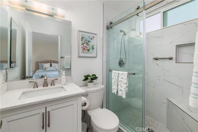 bathroom with toilet, vanity, and walk in shower