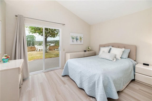 bedroom featuring lofted ceiling, light wood-type flooring, and access to outside