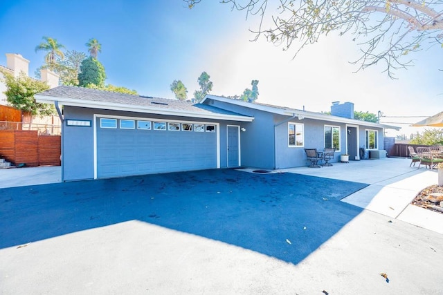 ranch-style house featuring cooling unit, a garage, and a patio area