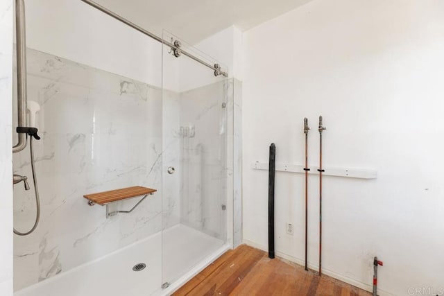 bathroom with hardwood / wood-style flooring and a shower with door