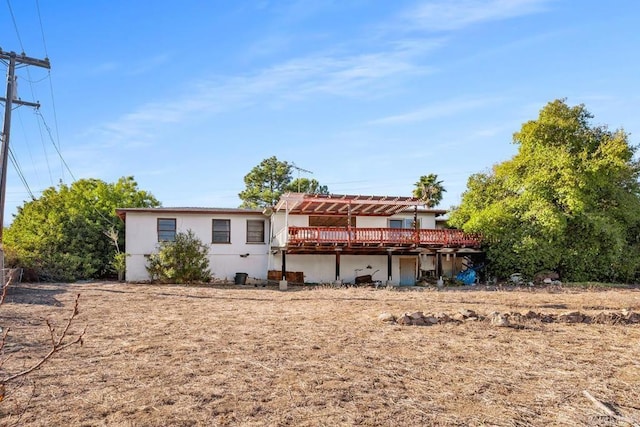 back of house with a wooden deck and a pergola