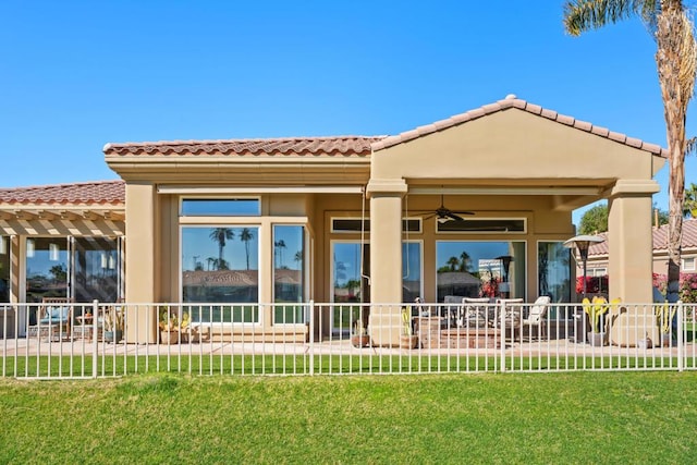 back of house with a yard and ceiling fan