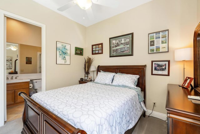 bedroom with light tile patterned flooring, ceiling fan, and ensuite bathroom