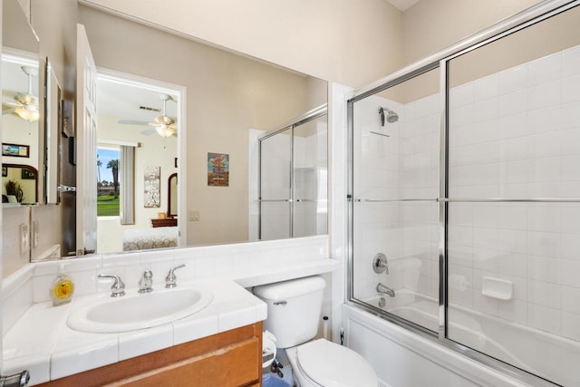 full bathroom featuring vanity, combined bath / shower with glass door, ceiling fan, and toilet