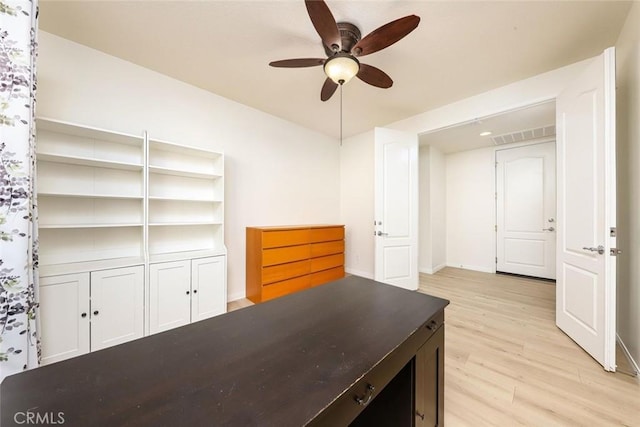 home office featuring light wood finished floors, visible vents, baseboards, and a ceiling fan