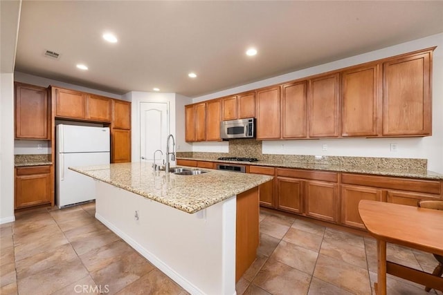 kitchen featuring appliances with stainless steel finishes, brown cabinets, and a sink