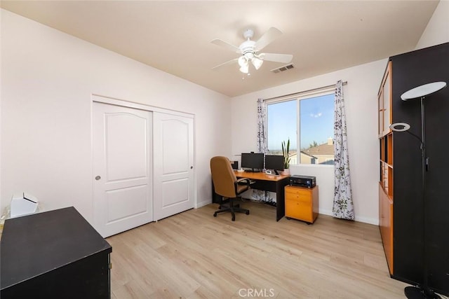 office with light wood-style flooring, visible vents, ceiling fan, and baseboards