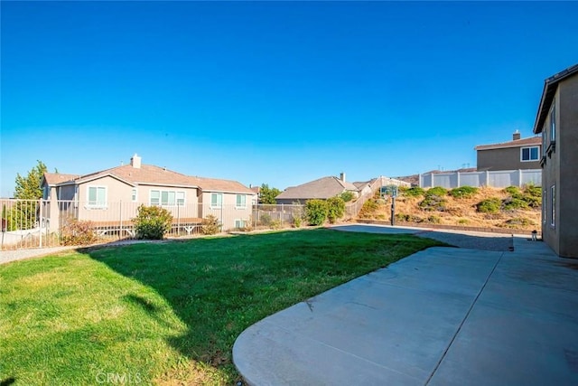 view of yard featuring a patio area, a fenced backyard, and a residential view