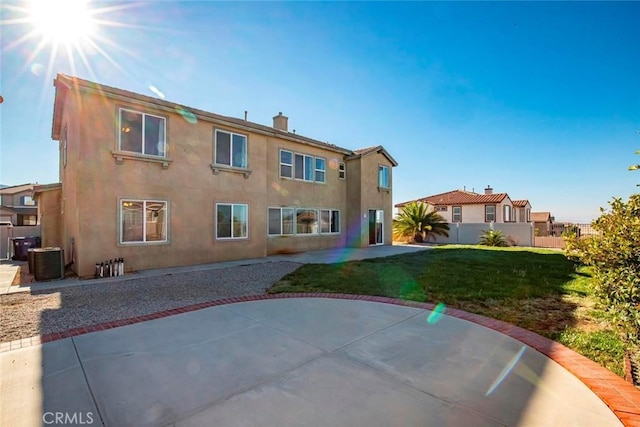 back of house featuring a patio area, a lawn, fence, and stucco siding