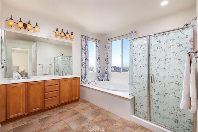 bathroom with double vanity, a stall shower, a garden tub, and a sink