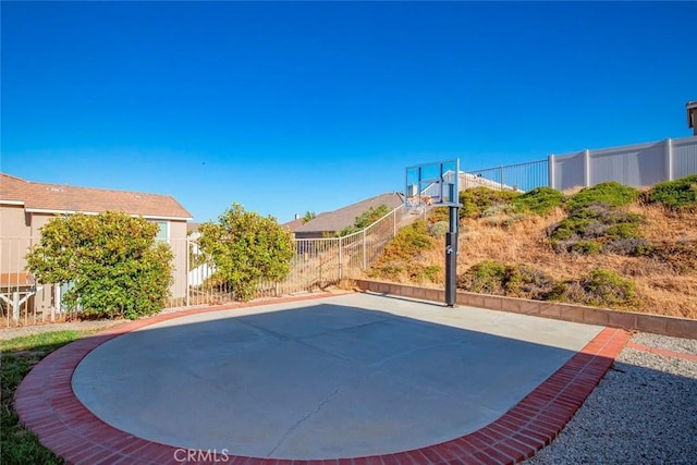 view of sport court featuring fence and basketball court