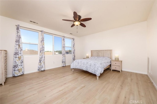 bedroom with baseboards, ceiling fan, visible vents, and light wood-style floors