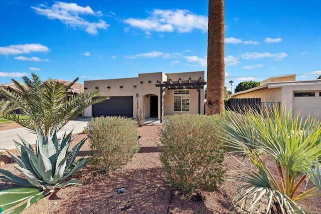 pueblo revival-style home with a garage and a pergola