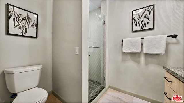 bathroom with vanity, toilet, and an enclosed shower