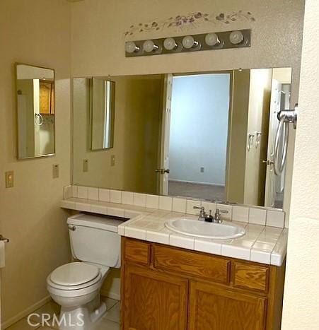 bathroom featuring vanity, toilet, and tile patterned flooring