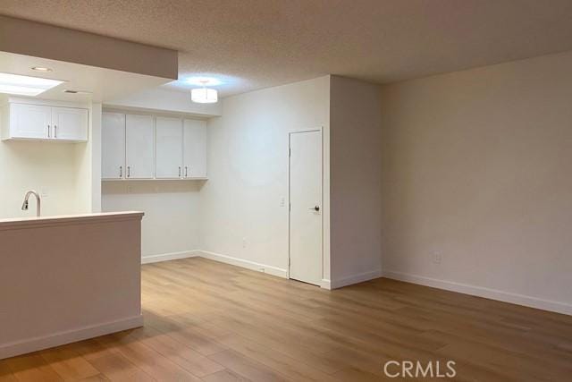 interior space featuring a textured ceiling and light hardwood / wood-style floors