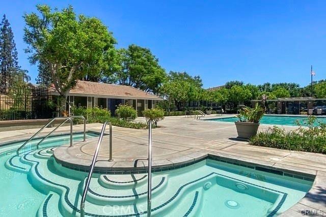 view of pool featuring a hot tub and a patio