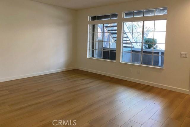 spare room featuring hardwood / wood-style floors and plenty of natural light