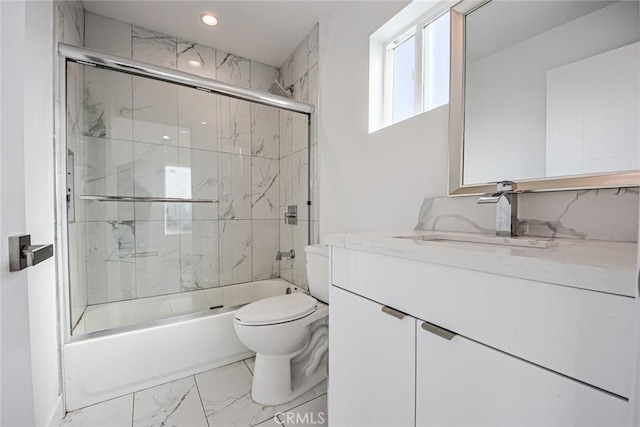 full bathroom featuring toilet, vanity, and bath / shower combo with glass door